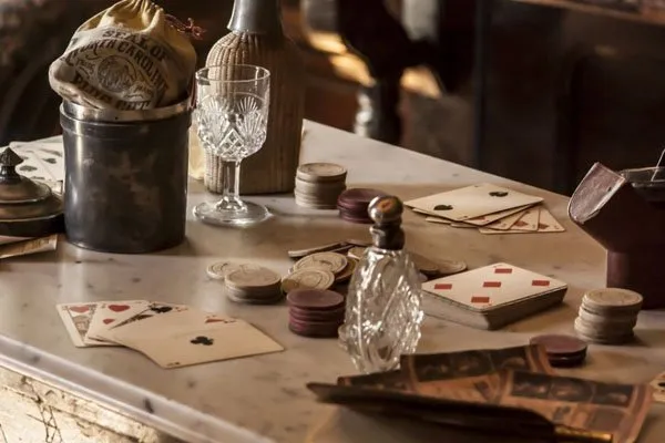 Ett gammeldags bord med pengar, spelkort och vinglas